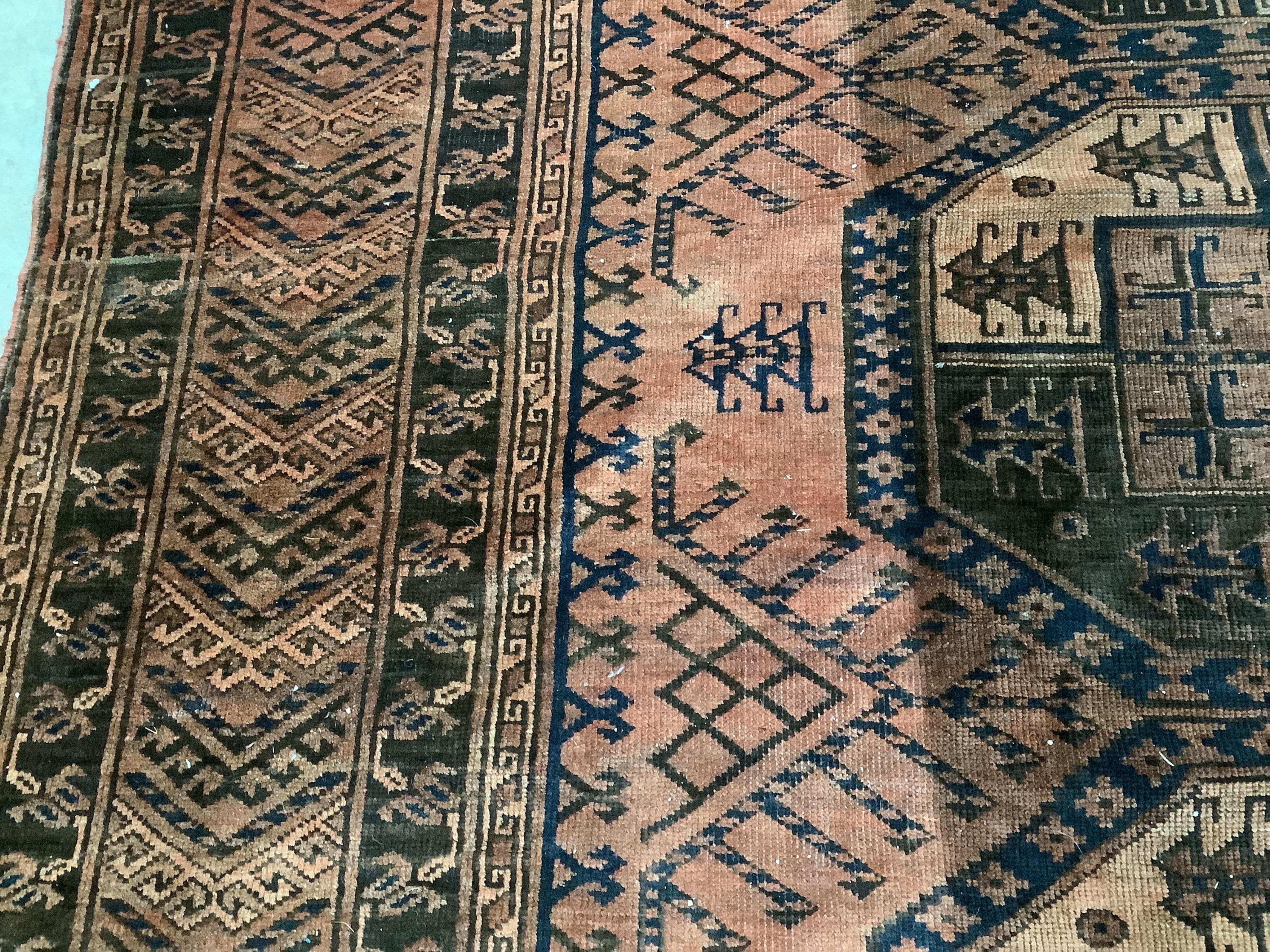 An Afghan rust ground carpet, 400 x 260cm. Condition - poor, damage to border